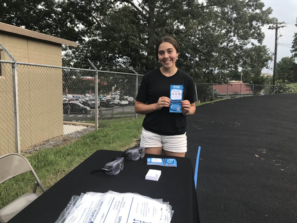 Imelia holds a YAC recruitment card at an Oak Ridge High School event.