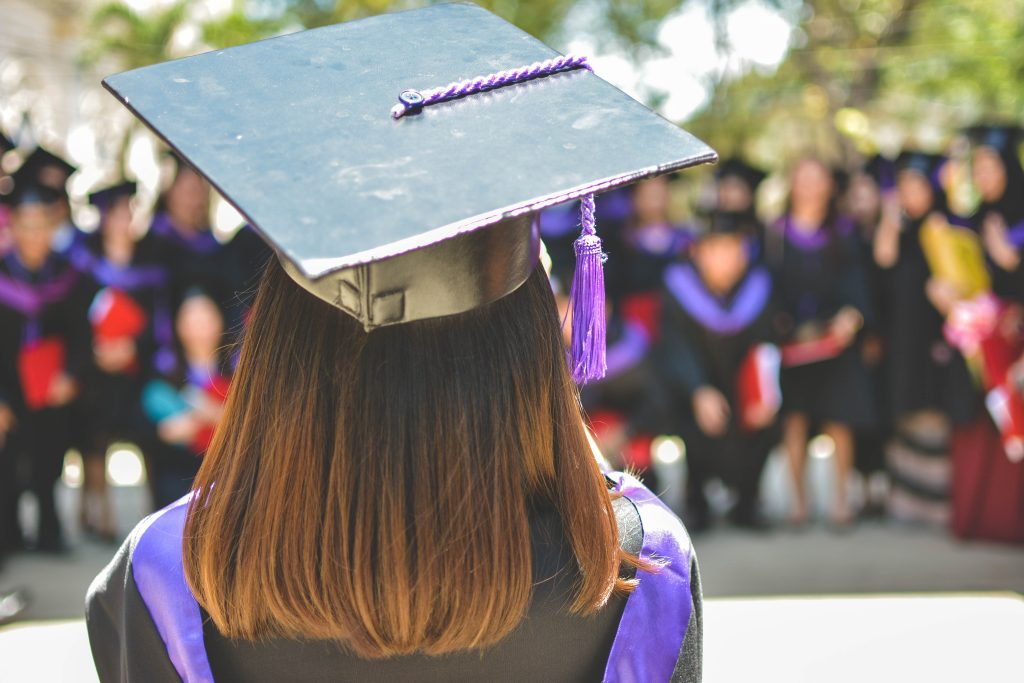 A graduate faces other graduates during a ceremony.